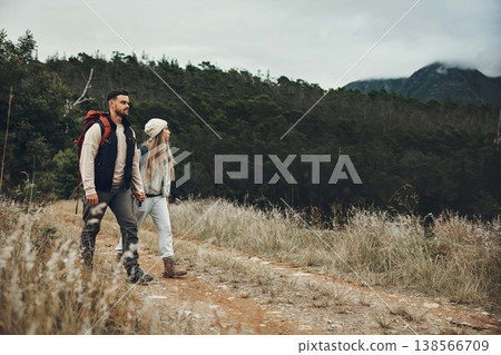 Couple walking, hiking and nature with travel, mountain and backpacking with wilderness and explore outdoor. People holding hands, adventure and holiday with date, environment and trekking path 138566709