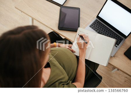 Pregnancy, business woman writing schedule in book or planning in office top view on laptop mockup. Pregnant secretary at desk working on notes for timetable, agenda reminder or list of receptionist 138566760