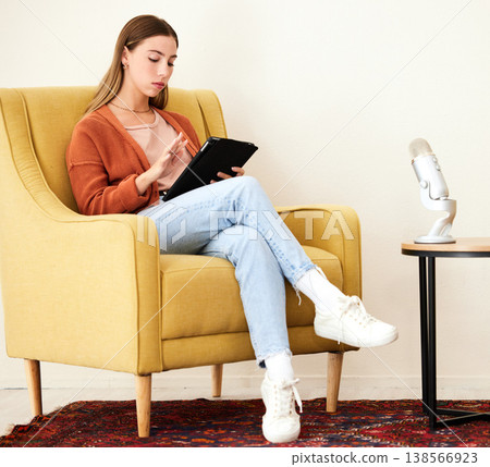 Tablet, microphone and woman on a chair for podcast doing research on internet or social media. Radio, serious and young female person scroll on mobile app with digital technology in recording space. Tablet, microphone and woman on a chair for podcast doing research on internet or social media. Radio, serious and young female person scroll on mobile app with digital technology in recording space. 138566923
