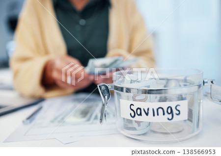 Woman, jar and savings for money, investment or growth in finance, profit or expenses on desk at home. Female person counting cash, bills or paper notes in financial freedom or interest in container 138566953