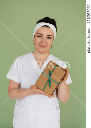 Portrait Of Happy Doctor Holding Present Box Portrait Of Happy Doctor Holding Present Box 138567062