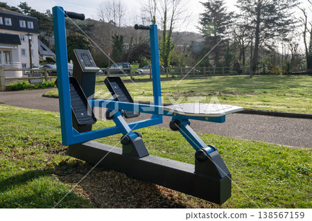 Outdoor fitness machine in park gym area public workout equipment in green urban landscape Outdoor fitness machine in park gym area public workout equipment in green urban landscape 138567159