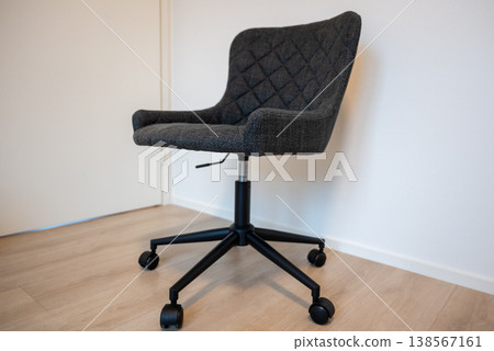 Modern ergonomic office chair with wheels in minimalist interior workspace clean Scandinavian design Modern ergonomic office chair with wheels in minimalist interior workspace clean Scandinavian design 138567161