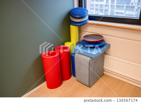 Colorful fitness equipment set with yoga mat foam roller balance pad and exercise tools in modern workout space Colorful fitness equipment set with yoga mat foam roller balance pad and exercise tools in modern workout space 138567174