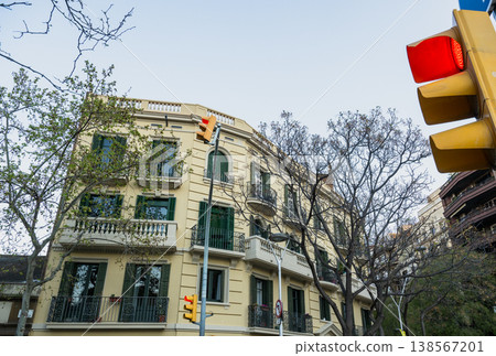 Classic residential building with green shutters and balconies at city intersection with red traffic light in Barcelona urban scene Classic residential building with green shutters and balconies at city intersection with red traffic light in Barcelona urban scene 138567201