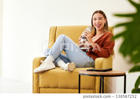 Microphone, production and happy woman hosting podcast on a chair by a wall in her modern home. Radio, broadcast and young female person hosting a journalism talk show in a recording space at house. 138567252