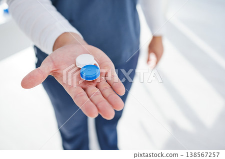 Health, eye care and hand of doctor with contacts in case for vision, help with eyesight and advice. Eyecare, solution and man giving lenses in container for eyewear, choice and option for sight. Health, eye care and hand of doctor with contacts in case for vision, help with eyesight and advice. Eyecare, solution and man giving lenses in container for eyewear, choice and option for sight. 138567257