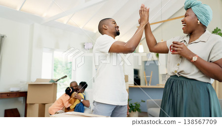 Moving, boxes and couple high five with black family in living room of new house, happiness and investing in home. African mother, father and children with achievement, real estate success and kids. Moving, boxes and couple high five with black family in living room of new house, happiness and investing in home. African mother, father and children with achievement, real estate success and kids. 138567709
