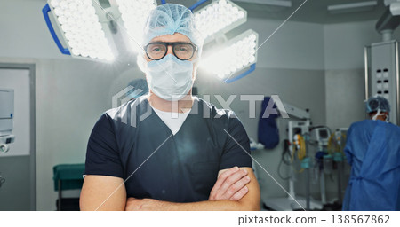 Surgeon, doctor and man in portrait with arms crossed, healthcare and confidence in operation theater for medical procedure. Surgery, health professional and help in hospital, expert with face mask 138567862