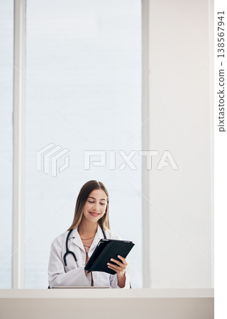 Female doctor, smile and reading on tablet in office for patient results, diagnosis or report. Face, woman and happy while looking at screen for treatment, healthcare or medicine with web or mockup Female doctor, smile and reading on tablet in office for patient results, diagnosis or report. Face, woman and happy while looking at screen for treatment, healthcare or medicine with web or mockup 138567941
