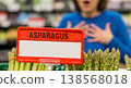 A woman's surprised reaction to fresh green asparagus in a supermarket with a blank price tag mockup - a concept for shopping, pricing, discounts and food choices. 138568018