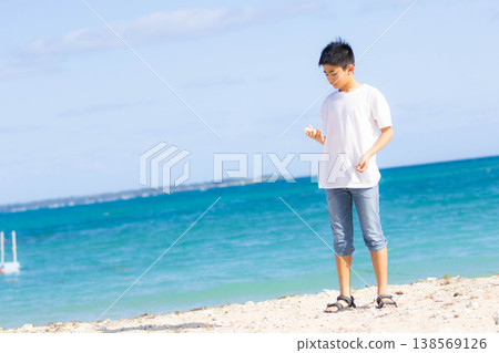 A boy enjoying his summer vacation by the sea in a tropical paradise. A boy enjoying his summer vacation by the sea in a tropical paradise. 138569126