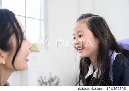 A Japanese parent and child holding hands and gazing into each other's eyes. A Japanese parent and child holding hands and gazing into each other's eyes. 138569138