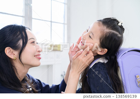 A Japanese girl having her cheek touched by her mother. A Japanese girl having her cheek touched by her mother. 138569139