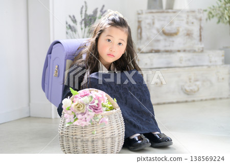 A Japanese girl sitting cross-legged, looking at the basket. A Japanese girl sitting cross-legged, looking at the basket. 138569224