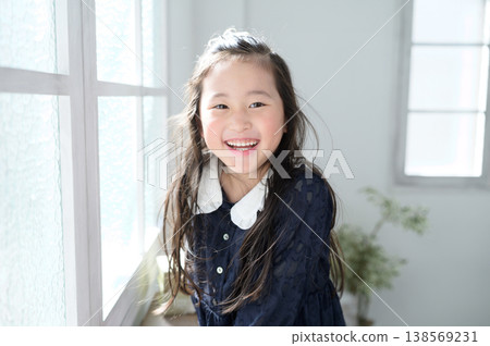 一位日本女孩站在窗邊,看著鏡頭。 一位日本女孩站在窗邊,看著鏡頭。 138569231