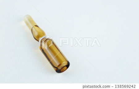 Close-up of a brown glass pharmaceutical ampoule filled with liquid medicine on white background Close-up of a brown glass pharmaceutical ampoule filled with liquid medicine on white background 138569242