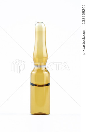 Close-up of a brown glass pharmaceutical ampoule filled with liquid medicine on white background 138569243