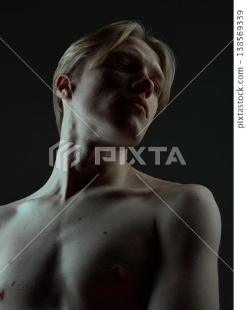 Stylish male portrait with structured face features and dramatic studio lighting. 138569339