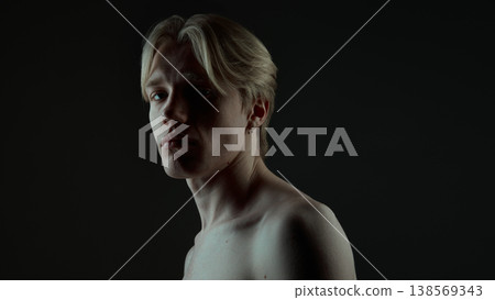 Dramatic male portrait with strong shadow lighting and expressive face in studio. Dramatic male portrait with strong shadow lighting and expressive face in studio. 138569343