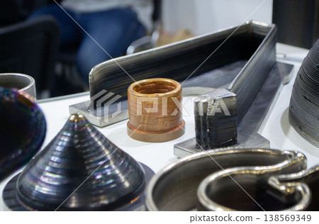 Object printing on 3D printer from melting metal thread. Model different shape printed on 3D printer from filament of molten metal. 3D printing modeling manufacturing technology Additive progressive Object printing on 3D printer from melting metal thread. Model different shape printed on 3D printer from filament of molten metal. 3D printing modeling manufacturing technology Additive progressive 138569349