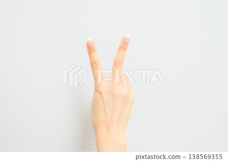 A Japanese woman's hand with natural nail polish, photographed against a white background. 138569355