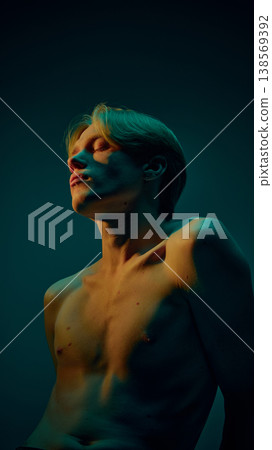 Young male body portrait with dramatic lighting and emotional pose in dark background. Young male body portrait with dramatic lighting and emotional pose in dark background. 138569392