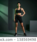 Portrait of a sporty girl in a black fitness suit in the gym. Modern cinematic lighting with green accent 138569498