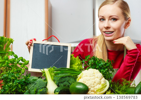 Woman having green vegetables holding board Woman having green vegetables holding board 138569783