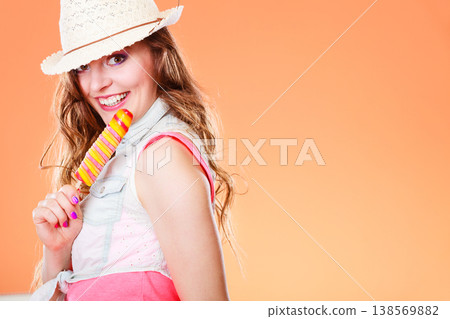 woman in summer hat eating ice pop cream woman in summer hat eating ice pop cream 138569882