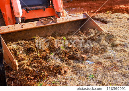 Heavy machinery works to move dirt debris in rural location during landscaping work with soil grass land clearing, Heavy machinery works to move dirt debris in rural location during landscaping work with soil grass land clearing, 138569991