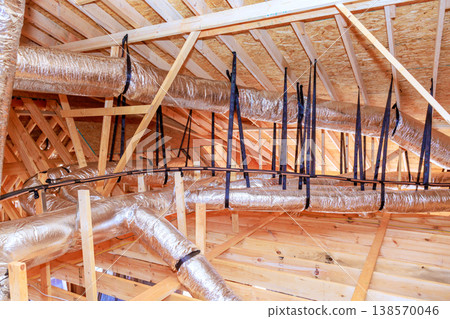 Workers install ductwork at ceiling of house being built this occurs in upper section of structure. Workers install ductwork at ceiling of house being built this occurs in upper section of structure. 138570046