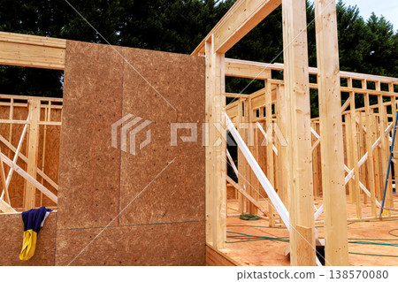 Workers are constructing house frame with wooden beams materials at construction site Workers are constructing house frame with wooden beams materials at construction site 138570080