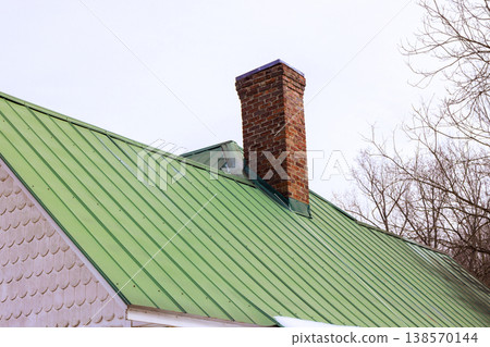 House has green roof, white siding setting is rural area with overcast skies above. House has green roof, white siding setting is rural area with overcast skies above. 138570144