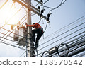 An electrician is working on a power pole. 138570542