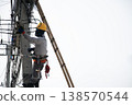 Electricians work on utility poles with safety as their top priority. 138570544
