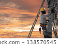 Electricians work on utility poles with safety as their top priority. 138570545