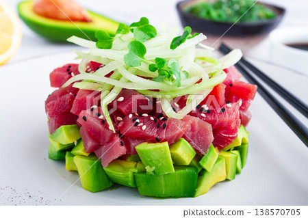 Fresh tuna tartare with avocado served on a marble table with soy sauce and seaweed salad 138570705