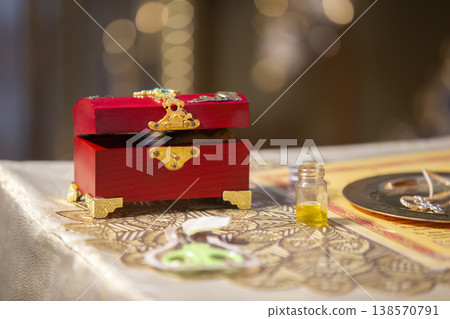 Decorative red jewelry box with intricate details and contents displayed on a decorative table during a celebration Decorative red jewelry box with intricate details and contents displayed on a decorative table during a celebration 138570791