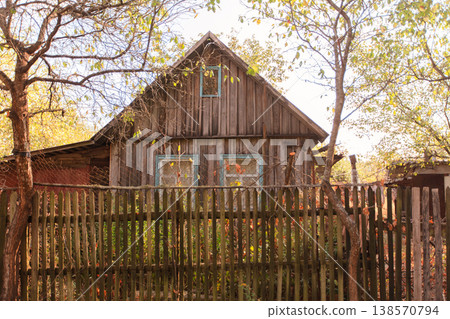 A small wooden country house on a summer street. The house is old and abandoned. A small wooden country house on a summer street. The house is old and abandoned. 138570794