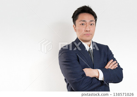 A Japanese man in a suit with a serious expression. 138571026