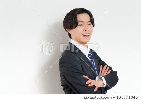 A young business person smiles while crossing their arms. 138571040
