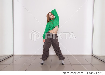 Dancer showcases movements in green outfit during studio practice session in bright space Dancer showcases movements in green outfit during studio practice session in bright space 138571273