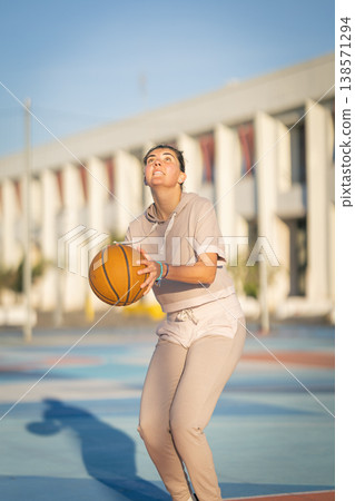 Young woman playing basketball focused on shooting Young woman playing basketball focused on shooting 138571294