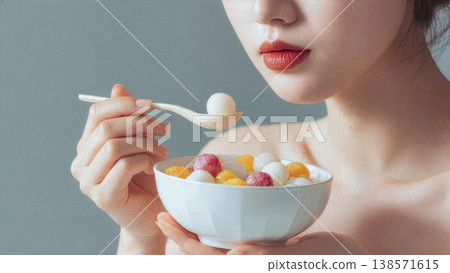 A woman holds a bowl of colorful Tangyuan, traditional Chinese glutinous rice balls, symbolizing family unity and harmony during the Lantern Festival or Winter Solstice. AI Generated 138571615