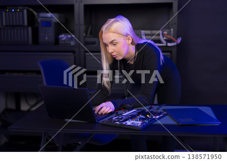 Female IT technician in her 20s repairing a laptop and motherboard in a tech lab Female IT technician in her 20s repairing a laptop and motherboard in a tech lab 138571950