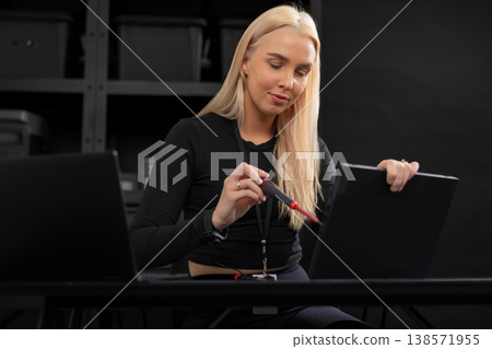 Female IT technician, young adult Caucasian, repairing a laptop with precision at a desk Female IT technician, young adult Caucasian, repairing a laptop with precision at a desk 138571955