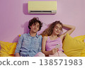 Man and woman resting beneath air conditioner, home cooling and relaxation concept 138571983