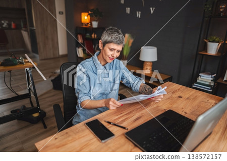 Woman carpenter reading instructions in her workshop at home 138572157