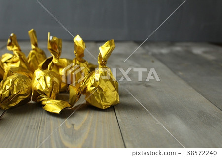 Chocolate corpus candies wrapped in a yellow wrapper on a gray background with space for copyspace text. Chocolate Day. 138572240